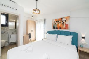 una camera da letto con un letto bianco con una testiera blu di Danai & Palm Residential Complexes a Ofrínion