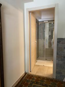 a bathroom with a shower and a glass door at Seraphic Home Garden in Taceno