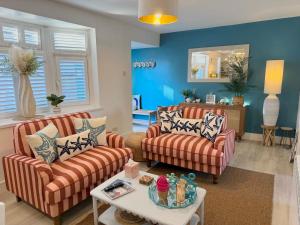 Una sala de estar con dos sofás y una mesa. en Luxury Coastal Escape with Mumbles Lighthouse View Pass the Keys, en Swansea