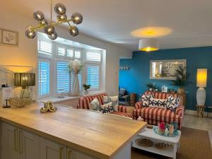 Una cocina y una sala de estar con mesa y sillas. en Luxury Coastal Escape with Mumbles Lighthouse View Pass the Keys, en Swansea