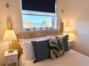 Un dormitorio con una cama y una ventana con el mar. en Luxury Coastal Escape with Mumbles Lighthouse View Pass the Keys, en Swansea