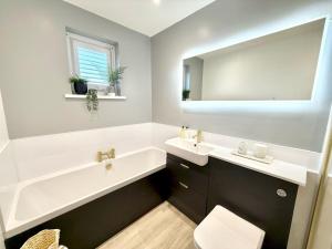 Un baño con bañera, lavabo y espejo. en Luxury Coastal Escape with Mumbles Lighthouse View Pass the Keys, en Swansea 37 fotos más