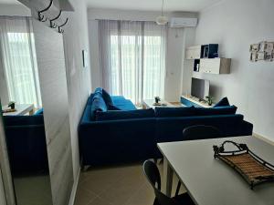 a living room with a blue couch and a table at Vlora Beach Apartment Orikum in Orikum