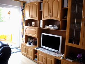 a living room with a television on a wooden entertainment center at Fewo 1 in Beverungen