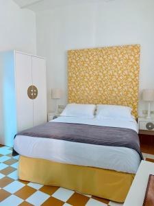 a bedroom with a large bed with a yellow headboard at Hostal Casa Alborada in Conil de la Frontera