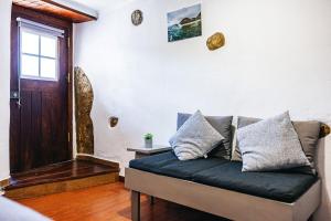 un canapé dans un salon avec une fenêtre dans l'établissement Private, romantic and cozy Room in Azenhas do Mar, à Colares 5 autres photos