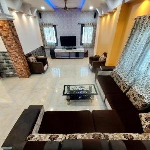 un ampio soggiorno con divani e TV di Skyline&Screen a Kolhapur