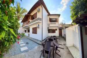 a patio of a house with tables and chairs at TuriHouse - Ilha Grande in Abraão