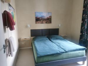a bedroom with a bed with a blue comforter at Ferienwohnung Potsdam in Potsdam +3 photos