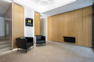 una sala de espera con 2 sillas y TV en H Pipera Lakeview, en Voluntari