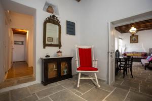 a room with a red chair and a fireplace at Traditional house in Sifnos in Apollonia +12 photos