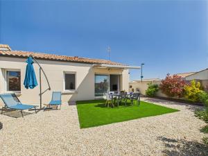 a patio with a table and chairs and an umbrella at Jolie maison pour 6 avec jardin in Saint-Vincent-sur-Jard