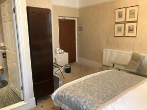 a bedroom with a bed and a chair in it at Chapel House in Atherstone