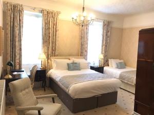 a bedroom with two beds and a desk and a chair at Chapel House in Atherstone