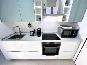 a small kitchen with a sink and a microwave at Augustus roman emperor in Lido di Jesolo
