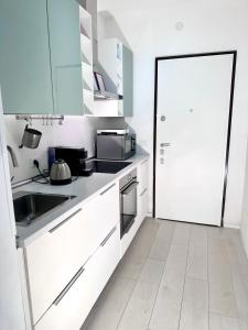 a kitchen with white cabinets and a sink and a door at Augustus roman emperor in Lido di Jesolo +7 photos