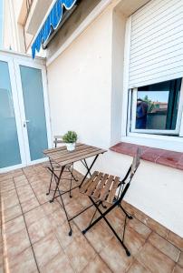 a picnic table and two chairs on a patio at Coma-ruga central beach apartment in Comarruga