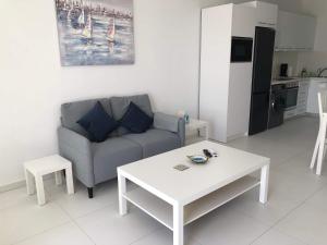 una sala de estar con un sofá y una mesa en Elegant beachside apt - 1 min walk to Venus beach, en Paphos