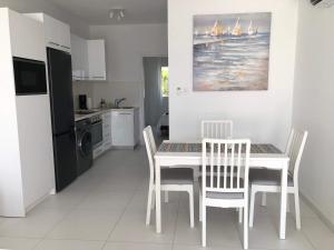 Una cocina con una mesa y sillas en una cocina. en Elegant beachside apt - 1 min walk to Venus beach, en Paphos