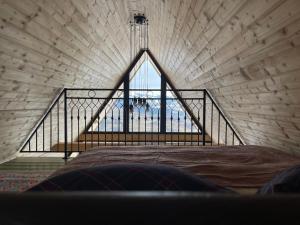 a bed in a room with a large window at Casa Boema- La noi la munte in Mătişeşti