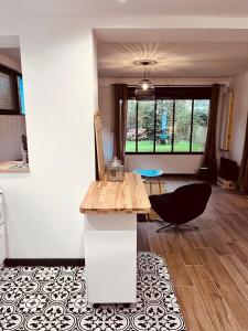 a living room with a table and a chair at Gîte de la Biscuiterie in Cucq +3 photos