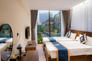 a hotel room with two beds and a large window at La Vie En Rose Villas - Flamingo Hải Tiến - Thanh Hóa in Thanh Hóa