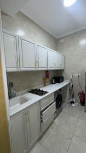 a kitchen with white cabinets and a sink and a stove at شقة لين طيبة للعوائل Leen Taibah Ap. for family's in Al Madinah