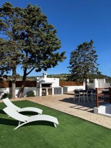 a lawn with a white chair on top of it at Casa Miele in Santa Lucia