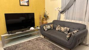 a living room with a couch and a flat screen tv at شقة لين طيبة للعوائل Leen Taibah Ap. for family's in Al Madinah