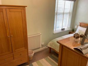 een slaapkamer met een bed, een bureau en een raam bij Number 10 service apartment - Danes in Southampton