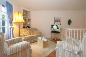 a living room with chairs and a table and a tv at Mecking in Munkmarsch