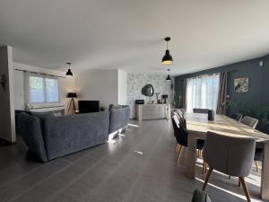 Una sala de estar con mesa de comedor y sillas. en Chez Choco - 8pers - Circuit Bugatti - Rêve au Mans, en Voivres-lès-le-Mans