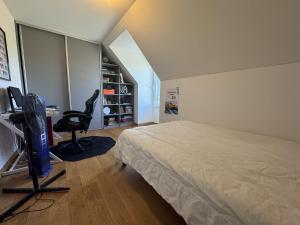 Un dormitorio con una cama, un escritorio y una silla. en Chez Choco - 8pers - Circuit Bugatti - Rêve au Mans, en Voivres-lès-le-Mans