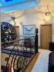 a spiral staircase in a room with a bird painting on the wall at Hostal Casa Alborada in Conil de la Frontera