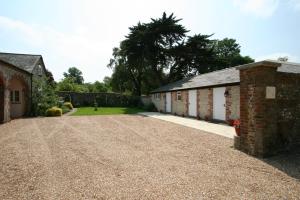 a gravel driveway in front of two buildings at Chilgrove Farm Bed & Breakfast in Chilgrove