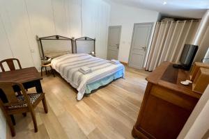 een slaapkamer met een bed, een tafel en een bureau bij L'Hermione - Room in the heart of St Martin de Ré in Saint-Martin-de-Ré +7 foto's