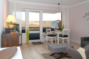 a living room with a table and a dining room at Haus Alice - Widlak 34/6 in Westerland +10 photos