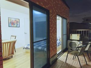 a balcony with sliding glass doors and a chair at #303WZNET梅屋敷駅2分横浜羽田空港都心便利商店街1ldk広い in Tokyo