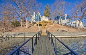 a wooden boardwalk leading to a house over the water at Lakefront Hgtv Home-3bed3bathdockfirepit-12pp in Lake Ozark