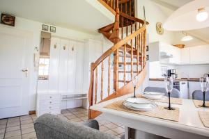 eine Küche mit einem Tisch und Stühlen sowie eine Treppe in der Unterkunft Alte Mühle in Keitum