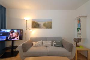 a living room with a couch and a flat screen tv at Haus Sylter Welle 4-32 in Westerland (Sylt)