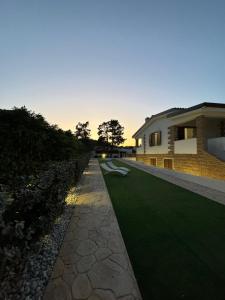 a house with a green lawn next to a building at Casa Miele in Santa Lucia