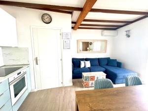 Una sala de estar con un sofá azul y una mesa. en Casa Caladero, en El Golfo