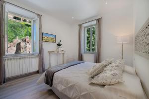 una camera bianca con un letto e due finestre di Siena Vip B&B a Siena