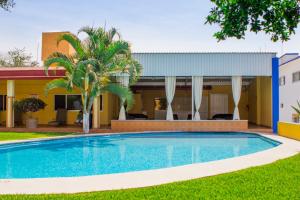 a swimming pool in front of a house with a building at Hotel Kazmay in Temixco