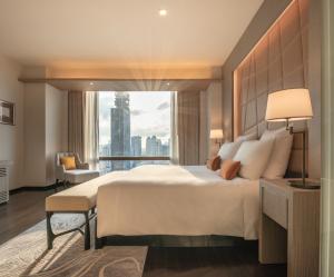 a bedroom with a large bed and a large window at VIE Hotel Bangkok - MGallery Collection in Bangkok