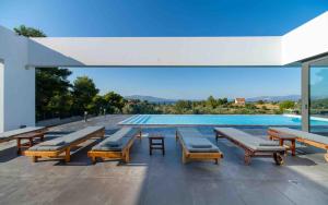 a swimming pool with wooden benches and a swimming pool at Villa Scorpios with private pool in Áyioi Apóstoloi