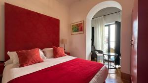 a bedroom with a large bed with a red headboard at Hostal Casa Alborada in Conil de la Frontera