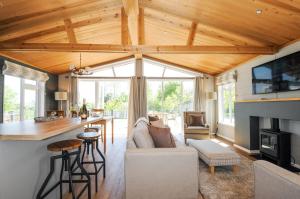 a living room with a couch and a kitchen with a counter at 17 Meadow Retreat in Liskeard