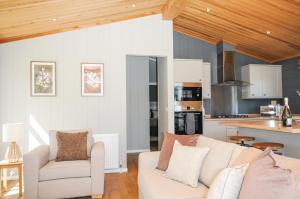 a living room with a couch and a kitchen at 17 Meadow Retreat in Liskeard